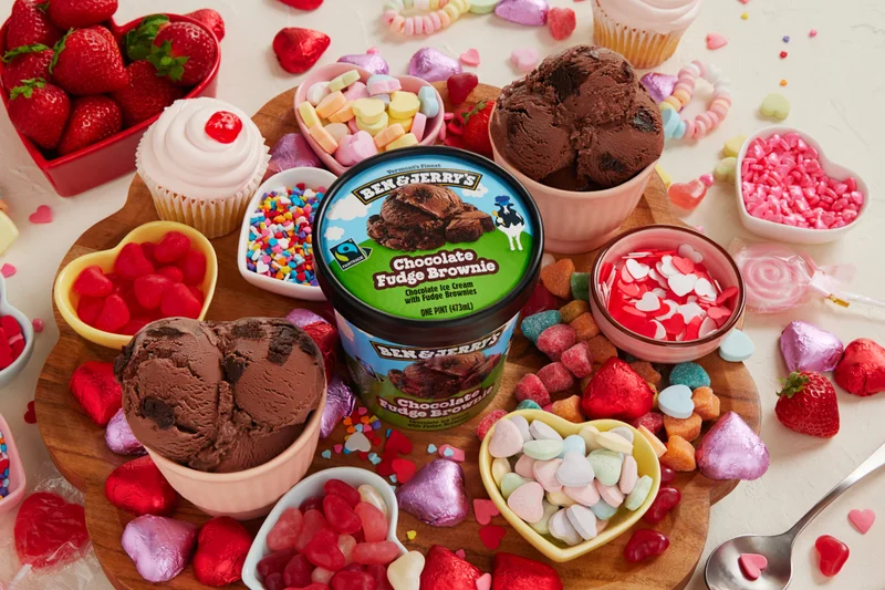 Pint of Ben & Jerry's Chocolate Fudge Brownie ice cream surrounded by Valentine's Day themed candies and treats.