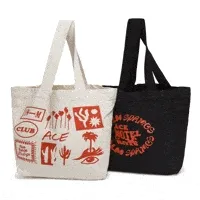 A pair of Ace Hotel canvas totes, one beige and one black, unfurling their unique designs in a lively GIF.