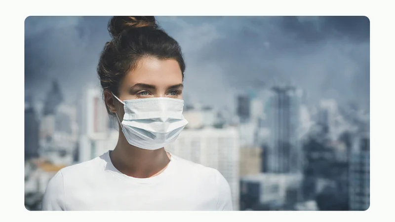 Woman with mask on her face with pollution in the air