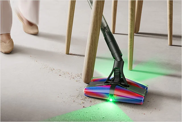 Dyson PencilVac cleaner pivoting between table and chair legs