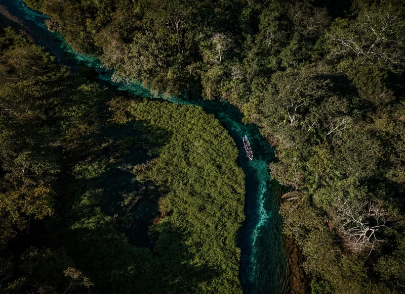An ecotourism boat is captured traveling upstream the crystal clear Sucuri river in Bonito, Brazil.