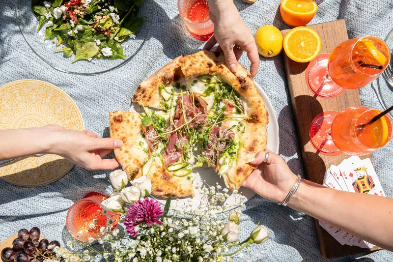 AperiBar picnic foods like pizza is getting shared in Bryant Park