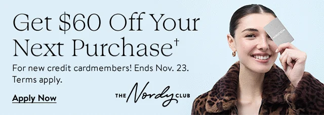 Woman smiling and holding a Nordstrom Visa® credit card.