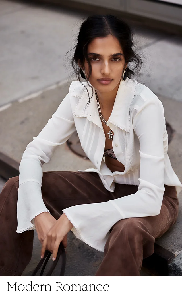 A woman wearing a white blouse and brown pants.