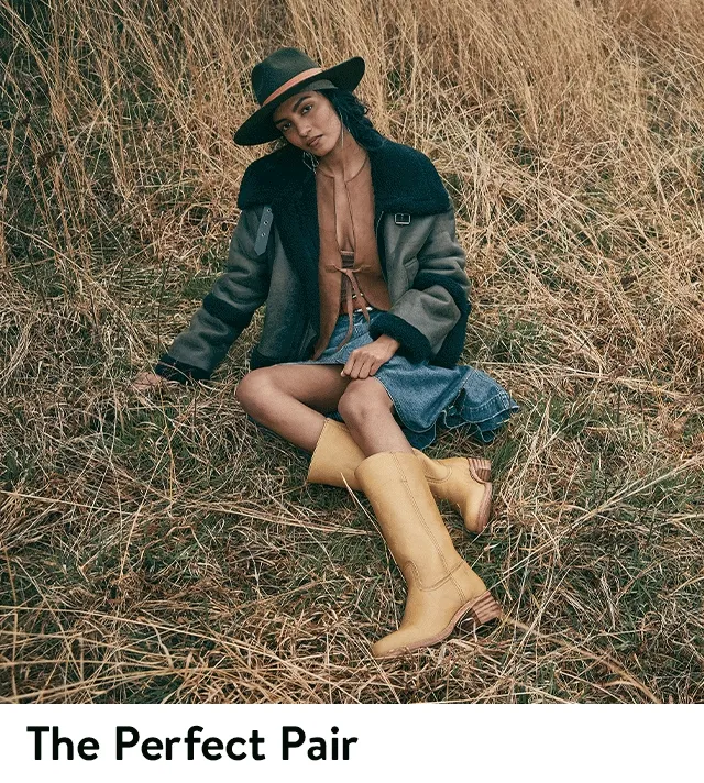 A woman wearing knee-high boots with a denim skirt.