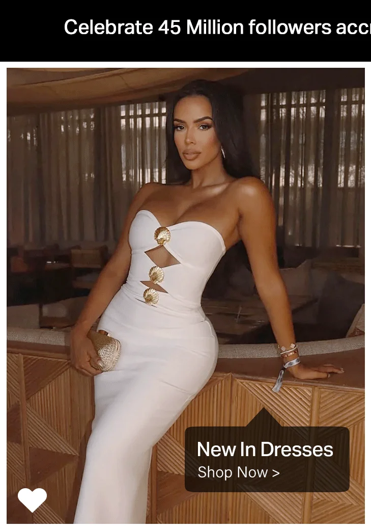 Woman in an elegant white strapless bodycon dress with gold shell details and cut-outs. Shop new dresses now.
