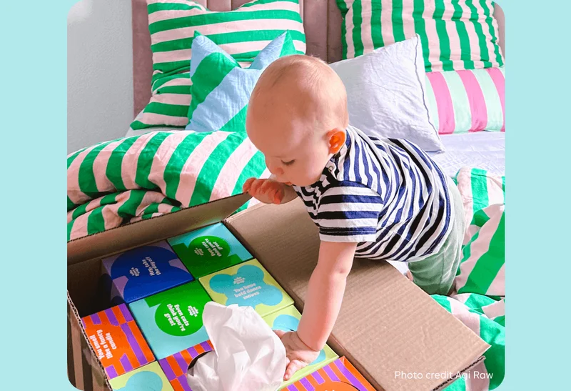 Image: Baby opening a box of Who Gives A Crap tissues