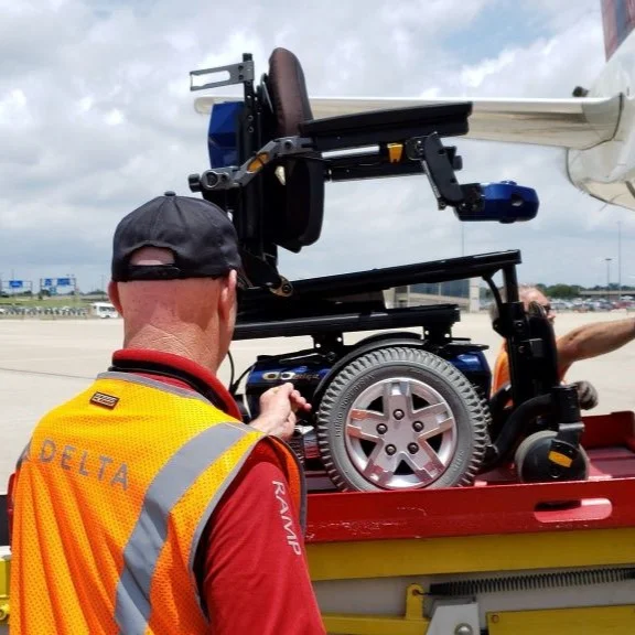 Delta ramp agents load a wheelchair onto a plane.