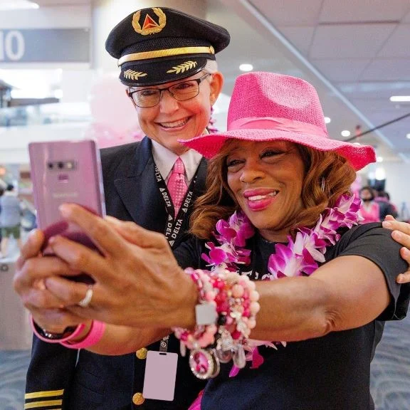 Delta employees snap a selfie before boarding Delta's Breast Cancer One charter