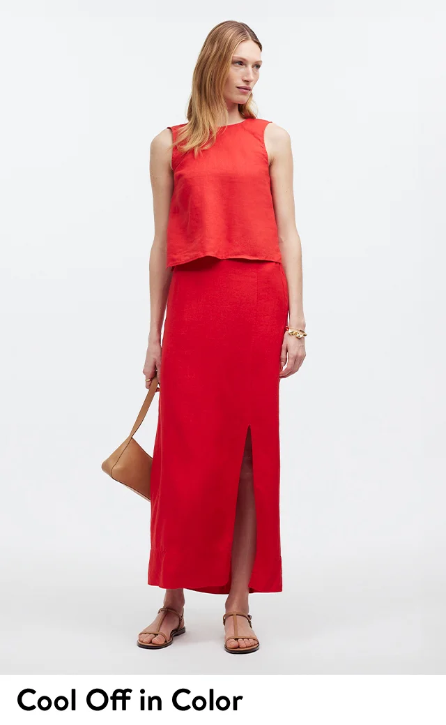 A woman wearing a red sleeveless top with a red maxi skirt.