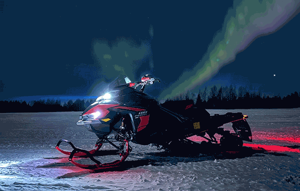 A Lynx snowmobile outdoors at night