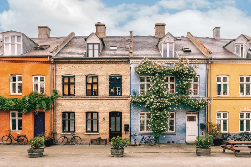 A row of colorful town homes under a blue sky.
