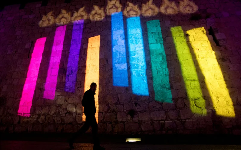 On the walls of Jerusalem's Old City, a colorful menorah lights up the night during Hanukkah.