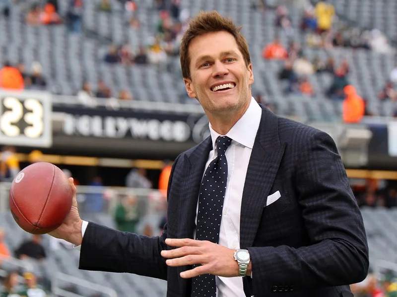 Image may contain: Tom Brady, Wristwatch, Arm, Body Part, Person, Accessories, Formal Wear, Tie, Adult, Clothing, and Suit