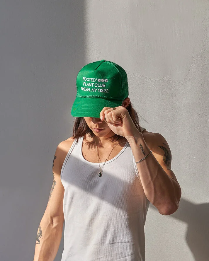 A person wearing a green Trucker Hat