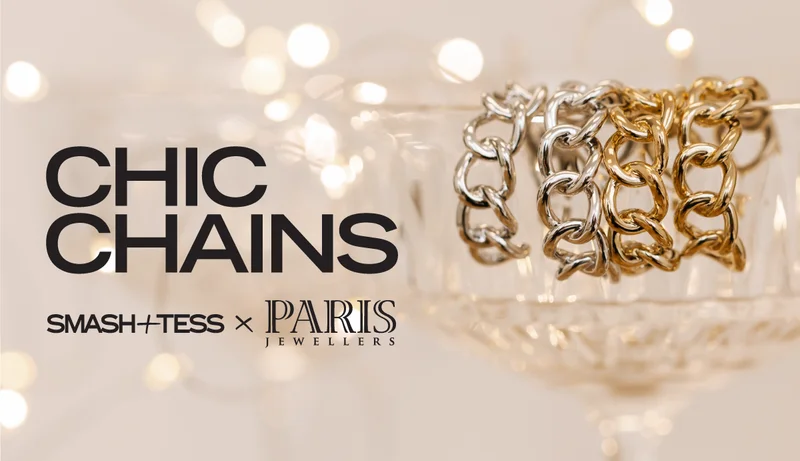 Close of up chain earrings draped over cocktail glass with text 'chic chains'