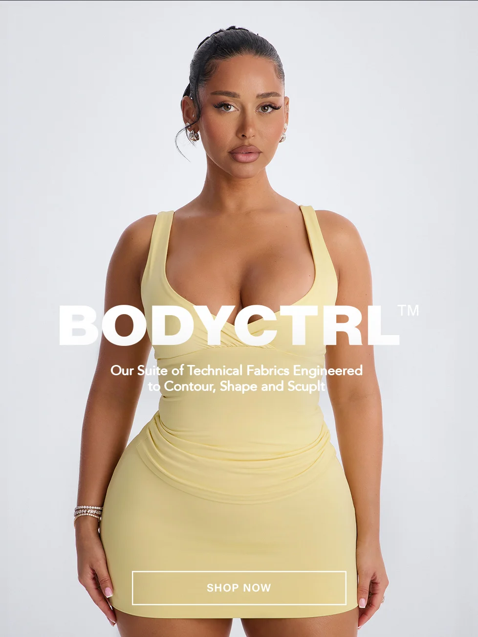 Woman models a yellow BODYCTRL contouring mini dress from a collection engineered with technical fabrics to shape and sculpt. Shop now.