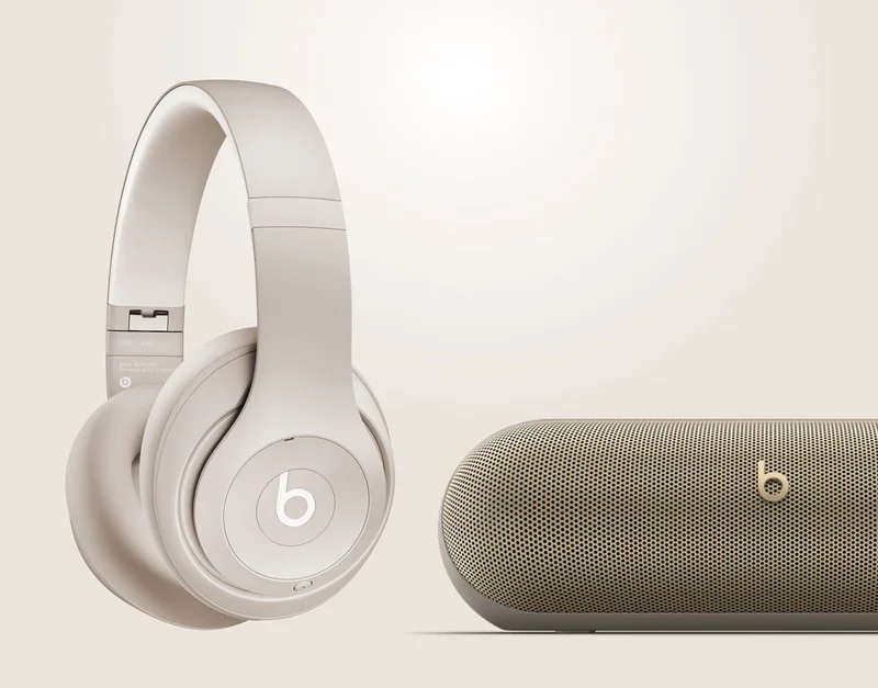 Beats Studio Pro in Sandstone next to Beats Pill in Champagne Gold.