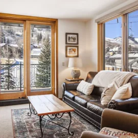 A nice hotel living room, the snowy Park City mountains visible through the windows.