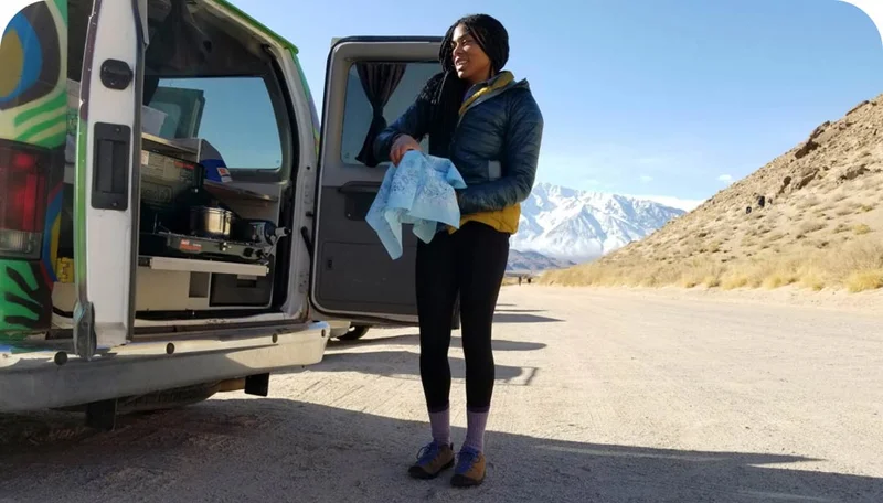 Brittany Leavitt standing outside of her van drying something.