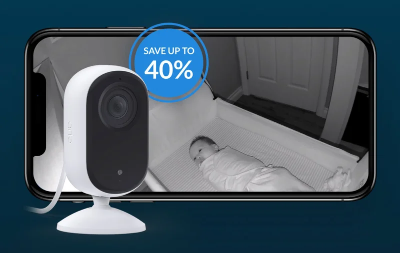 Up to 40% off. Essential 2K Indoor Camera next to a phone with a simulated Arlo screen image showing a point-of-view image of a baby in a crib at night.