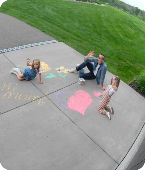 Point of view image from an Arlo Wired Floodlight of a family in a driveway.