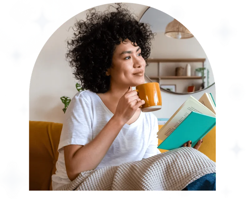 Woman with cup of coffee at the window enjoying the sunshine