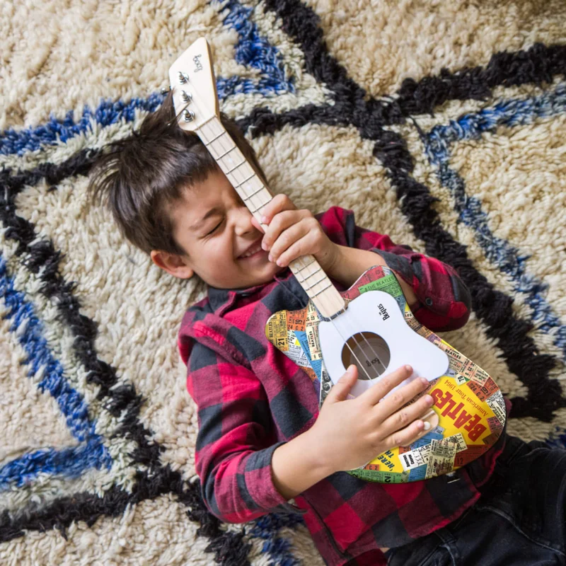 Kid playing with a Loog Guitar