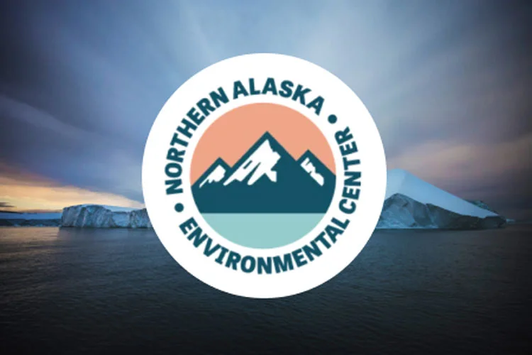 Photo of a large iceberg under a colorful and cloudy sky.