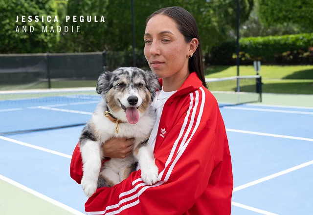 Jessica Pegula holding a dog on a tennis court