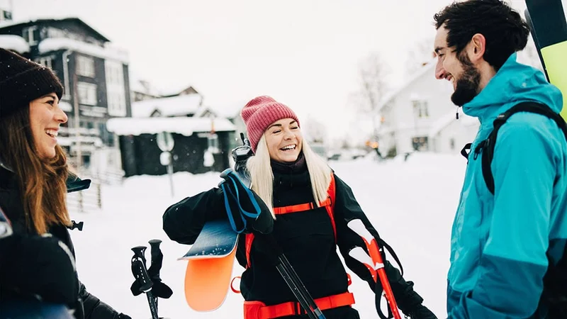 Image description: Group of friends talking and laughing at ski resort