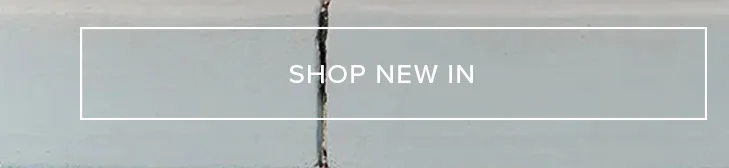 Light gray banner with white 'SHOP NEW IN' text, signaling new arrivals. Textured gray background with a central dark crack accent.