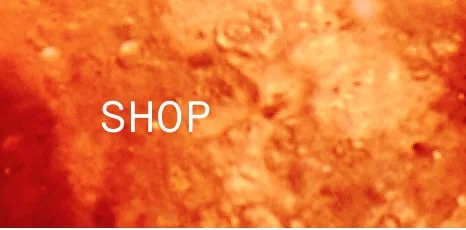 Orange-toned textured background with the word ‘SHOP’ in white capital letters centered. Minimalist design leading to shopping section.