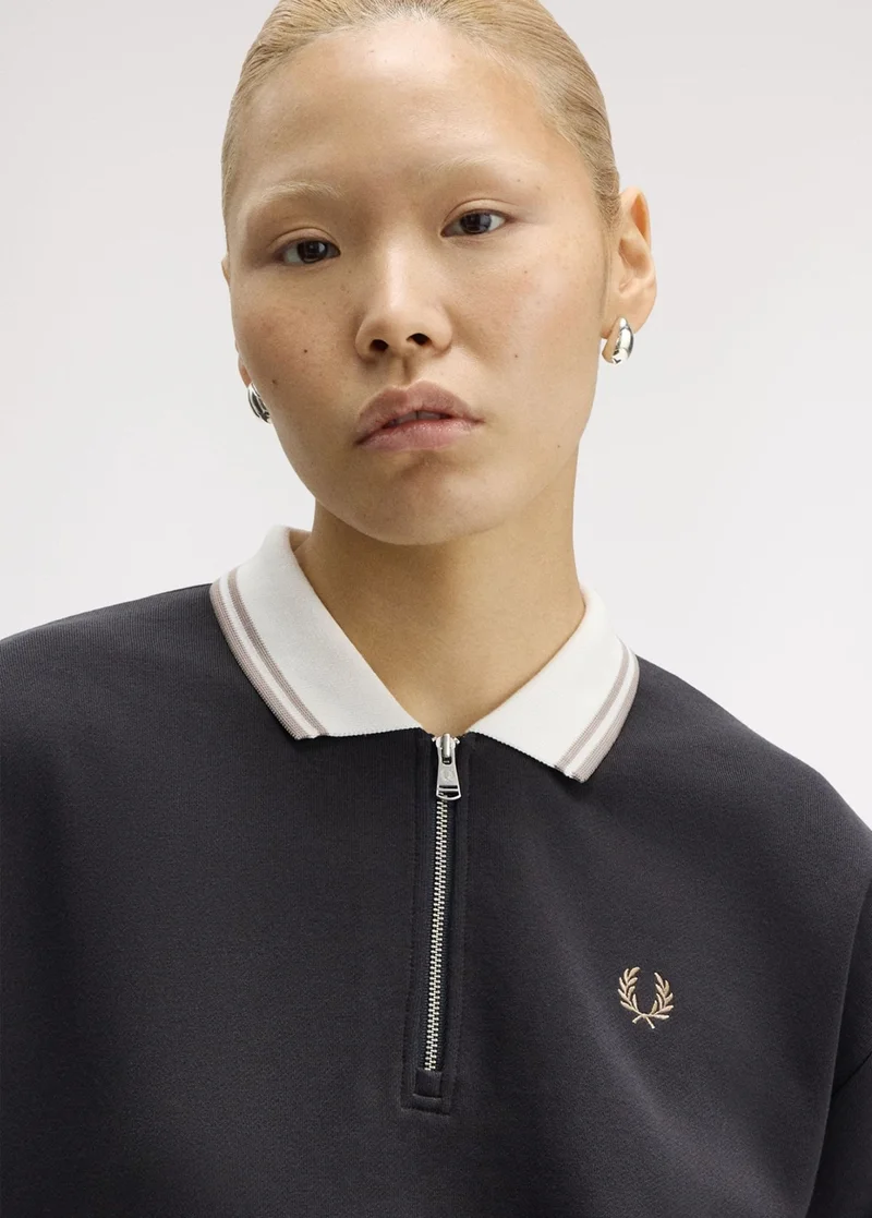 Female Asian model wearing a Fred Perry Zip Neck Collar Sweatshirt in Anchor Grey