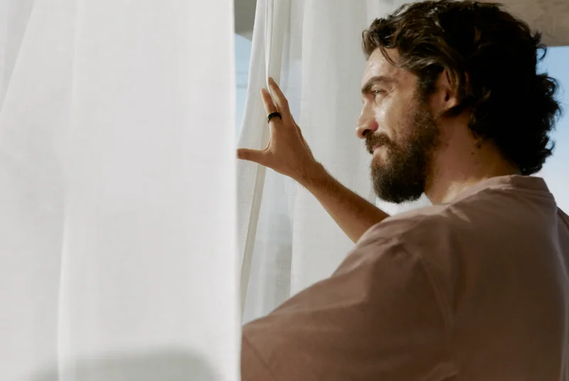 Person wearing Oura Ring looking out a window