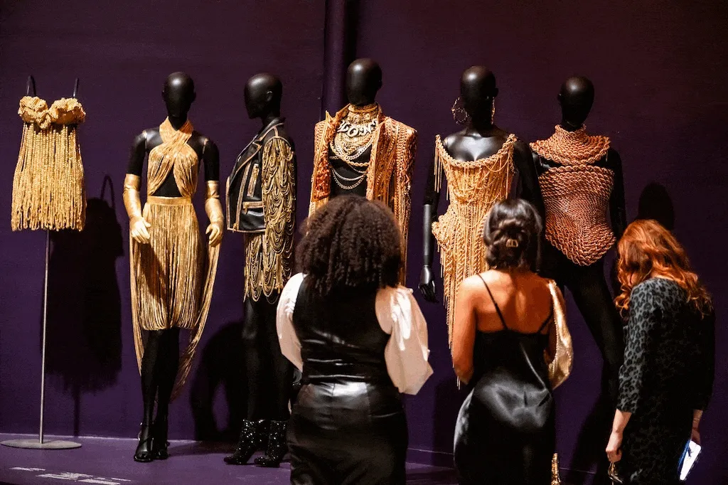 A GIF of visitors looking at art in the exhibition “Solid Gold”