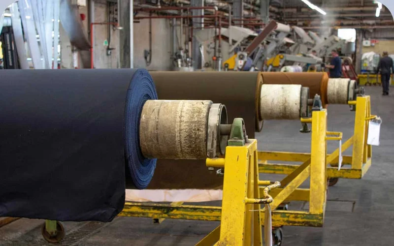 Large rolls of fabric inside a factory.