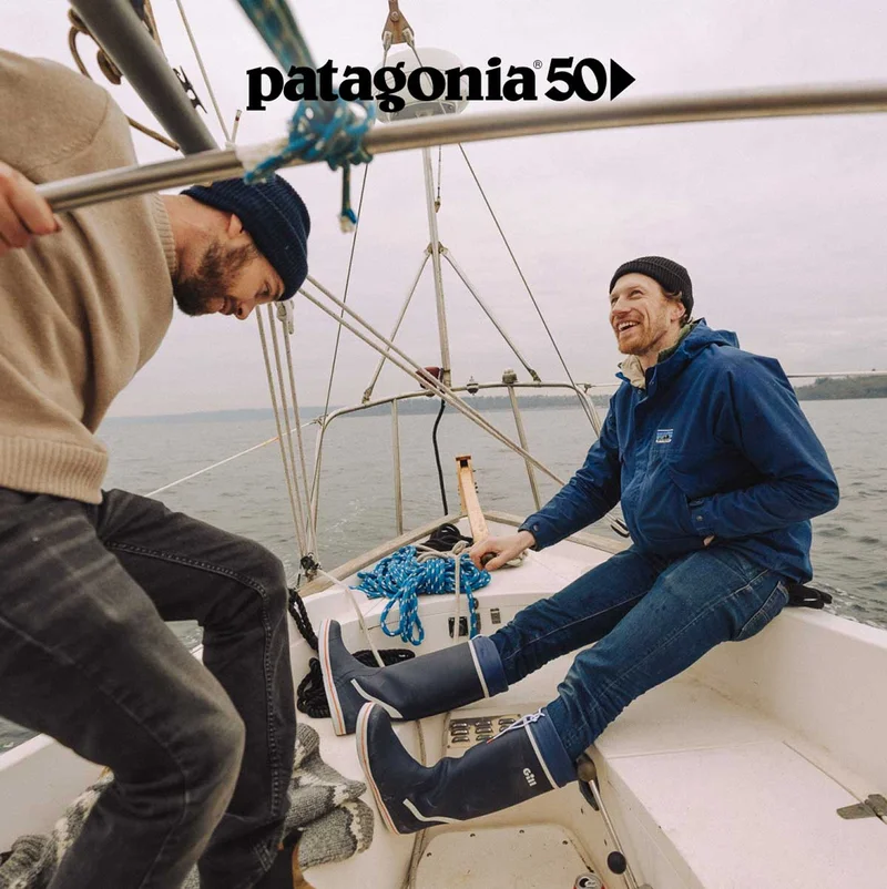 Two people on a sailboat in open water.