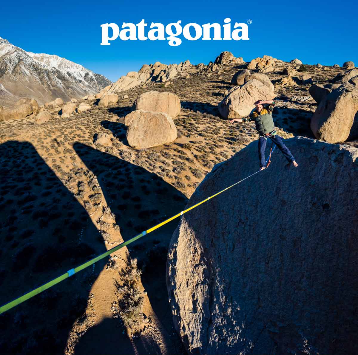 A person slacklining between two huge boulders.
