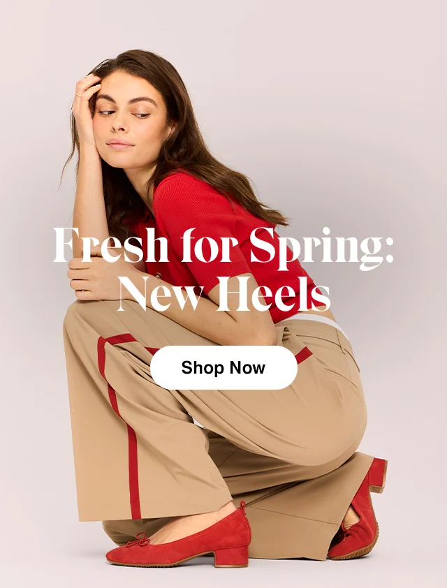 Woman kneeling in red top, wide-leg trousers and the new-for-spring Cranberry suede Netty pump with a low block heel.