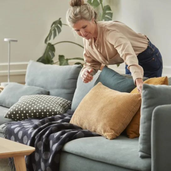Person fluffing a pillow