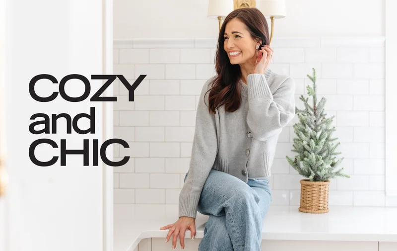 Tori Wesszer sat on white kitchen surface wearing grey cardigan and jeans next to small christmas tree