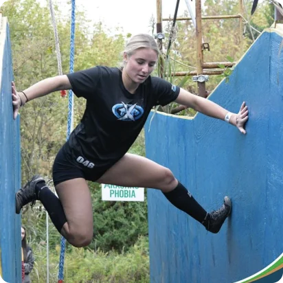 A person climbing through an obstacle of a Goliathon race