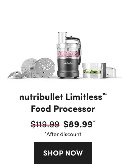 A black food processor filled with chopped red onions, surrounded by various blades and a container of sliced cucumbers.