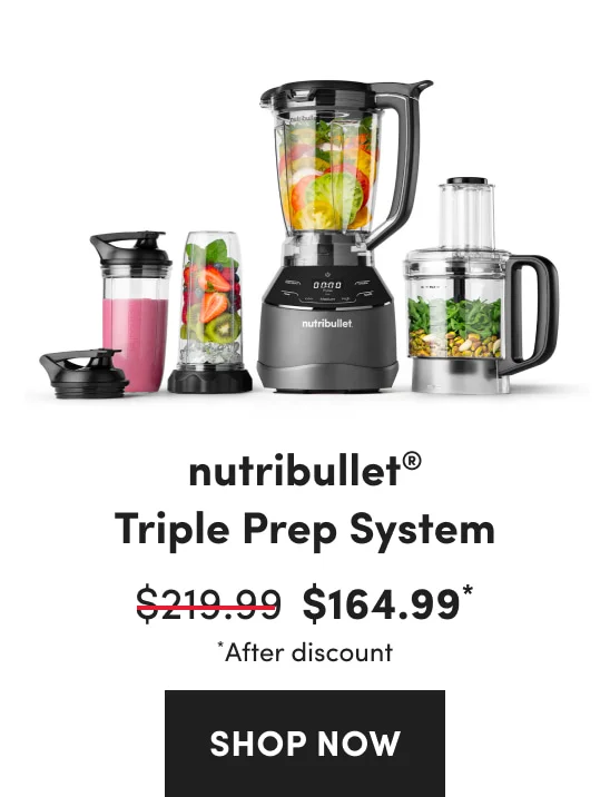 A collection of black blenders and a food processor filled with leafy greens, nuts, sliced tomatoes, and strawberries.