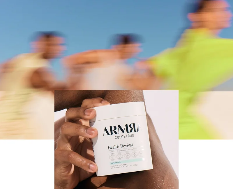 Hand holding a white ARMRA Colostrum Health Revival container outdoors, with motion-blurred figures running in the background.