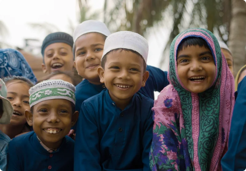 Young school children smiling in Bangladesh.