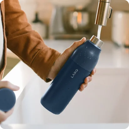 An image of a person filling up a LARQ water bottle.