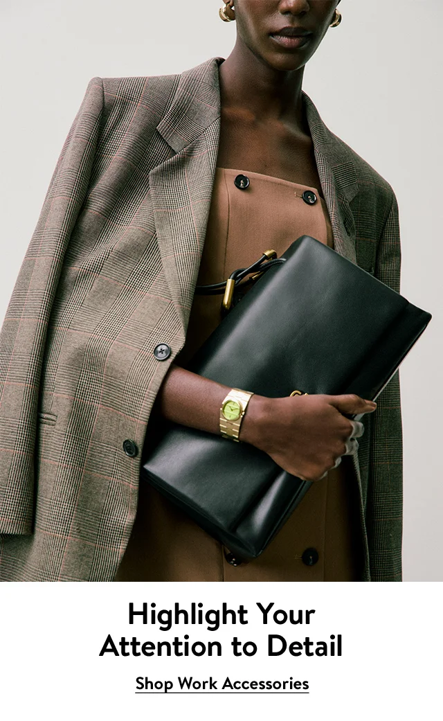 A woman wearing business attire, gold earrings and a gold watch. She holds a black handbag.