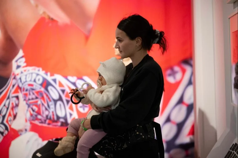 A woman holding a baby in an art gallery